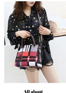 Detail of color-block plaid handbag featuring metal tassel and brown leather handles