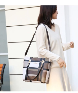 Close-up of a large capacity plaid tote bag with metallic chain and leather handles