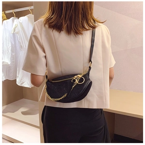 Detail view of black rhinestone crescent shoulder bag with gold chain and metal ring pull