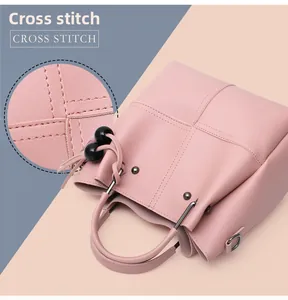 Detail view of pink leather handbag showing professional cross stitch and beaded charms