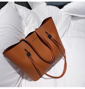 Detail of a brown minimalist tote bag with Forever Young text on white bedding background