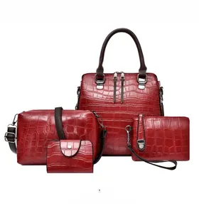 Détail d'un ensemble de quatre sacs rouges à motif crocodile avec boucles en métal