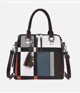 Detailed front view of color-block tote bag with geometric patterns and cat charm