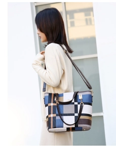 Close-up of geometric patchwork tote bag with gold logo and premium faux leather straps