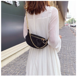 Close-up of black rhinestone moon bag featuring a bold gold chain strap for luxury style