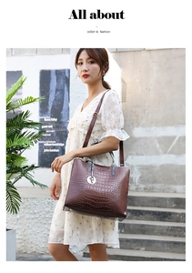 Detail of brown crocodile pattern tote bag with adjustable strap and metal letter F pendant