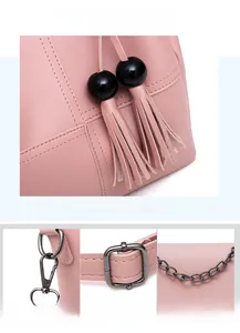 Detailed view of pink PU leather handbag featuring wooden beads and tassel decorations