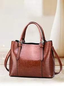 Close-up of vintage brown leather handbag featuring durable nylon stitching and silver hardware