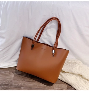 Macro shot of dark brown leather tote bag featuring Forever Young embossed lettering