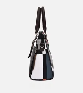 Close-up of geometric patchwork canvas tote with leather handles and side zipper details