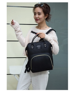 Front detail of black waterproof backpack with U-shaped zipper and travel patch logo