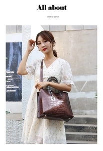Detail of dark brown crocodile embossed leather handbag with metal F pendant