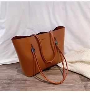 Detailed shot of caramel brown tote bag with Forever Young text and long shoulder straps
