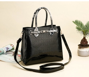 Detail of black crocodile texture and snake skin pattern stitching on luxury handbag
