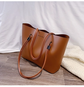 Close-up of brown faux leather tote with Forever Young text and metallic hardware details