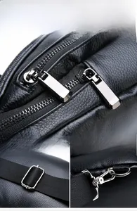Close-up of silver metal zippers and hardware buckles on black crocodile pattern chest bag