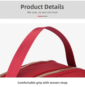 Close-up of red nylon oxford fabric handbag with gold metal zippers and woven handle