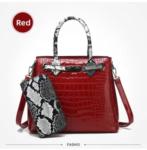 Detail of red crocodile texture handbag and snake pattern wallet set with silver hardware