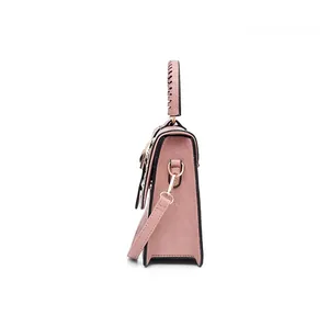 Detail view of pink lychee leather handbag side showing woven handle and golden hardware