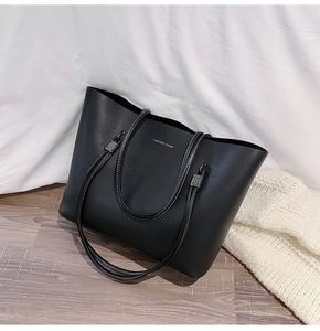 Detail of black matte tote bag with Forever Young gold text and contrast stitching