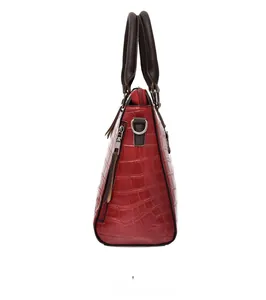 Vue latérale du sac rouge à motif crocodile avec anses brunes et détails argentés