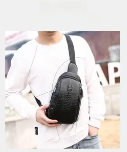 Detail of black crocodile texture chest bag for men showing zipper and adjustable strap