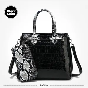 Detail of black crocodile texture handbag with snake pattern handle and matching clutch bag