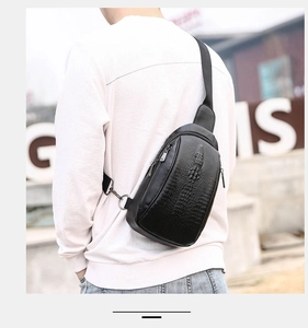 Close-up of black crocodile texture chest bag with silver zipper on a male model