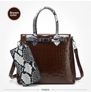Detail of brown croc-effect handbag with snakeskin print handles and matching long wallet
