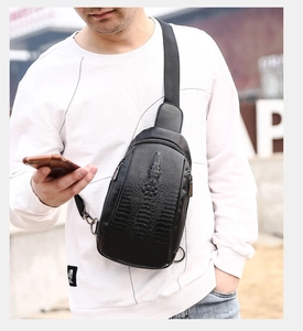 Detail of 3D embossed crocodile head texture on black leather men's chest bag