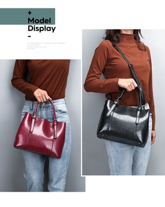Detail view of burgundy and black patent leather tote bags with glossy cracked texture