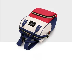 Detailed top view of the tricolor canvas backpack with reinforced handles and brand patch