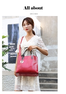 Close-up of red crocodile embossed tote bag with animal print handles and metal charm