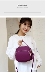 Detail view of the multi-layer zipper and durable nylon material on this purple crossbody bag