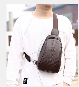 Detail of dark brown faux leather chest bag featuring 3D embossed crocodile texture