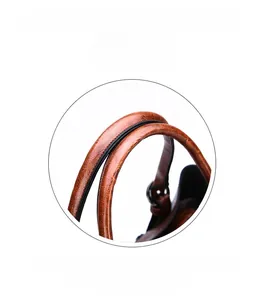 Close-up of vintage brown leather handbag featuring dual arched top handles and lychee texture