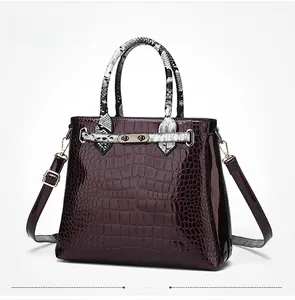 Detail view of purple faux crocodile texture bag with snakeskin pattern handles and gold lock
