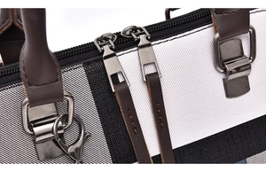 Close-up of dual zippers and durable stitching on the striped canvas handbag detail