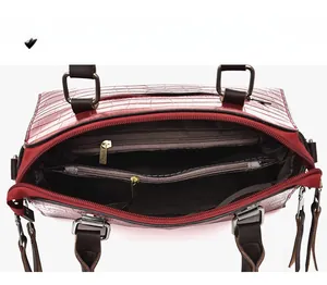 Détail du sac à main rouge à motif crocodile avec multiples compartiments zippés internes