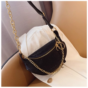 Detail of black rhinestone crescent bag with gold chain and luxury crystal texture