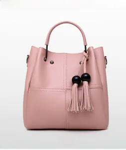 Detailed front view of lotus pink bucket bag with black bead tassel and stitch textures