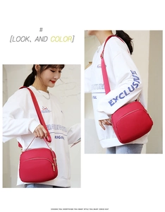 Detail view of a red waterproof Oxford crossbody bag with three zipper compartments
