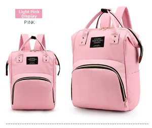 Front detail of light pink diaper backpack with logo patch and zipper pockets