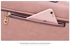 Detailed view of pink pebble leather handbag showing a rear zipper pocket with a smartphone