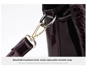 Detail of detachable gold-plated hardware and crocodile texture on luxury tote bag