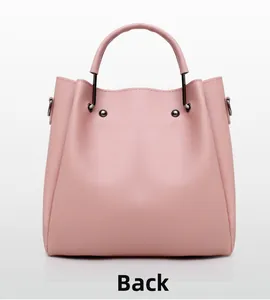 Detail view of pink leather handbag back showing cylindrical handle and rivets
