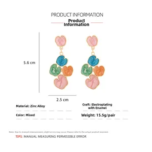 Détail montrant les dimensions des boucles d'oreilles cœur en émail de 5,6 cm de hauteur