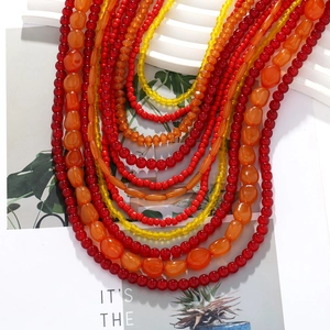 Detail of layered bohemian necklace with red, orange and yellow resin beads