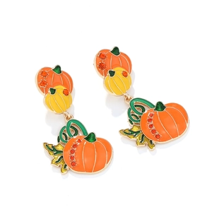 Close-up of Halloween pumpkin drop earrings with tiered enamel design and orange rhinestones