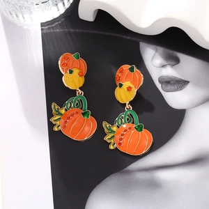 Detailed view of Halloween pumpkin drop earrings with orange crystals and enamel finish